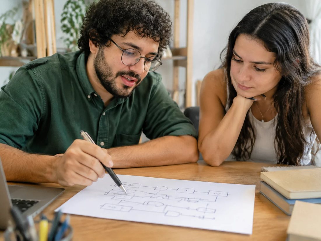 Dupla relendo anotações num tablet apoiado na mesa de madeira